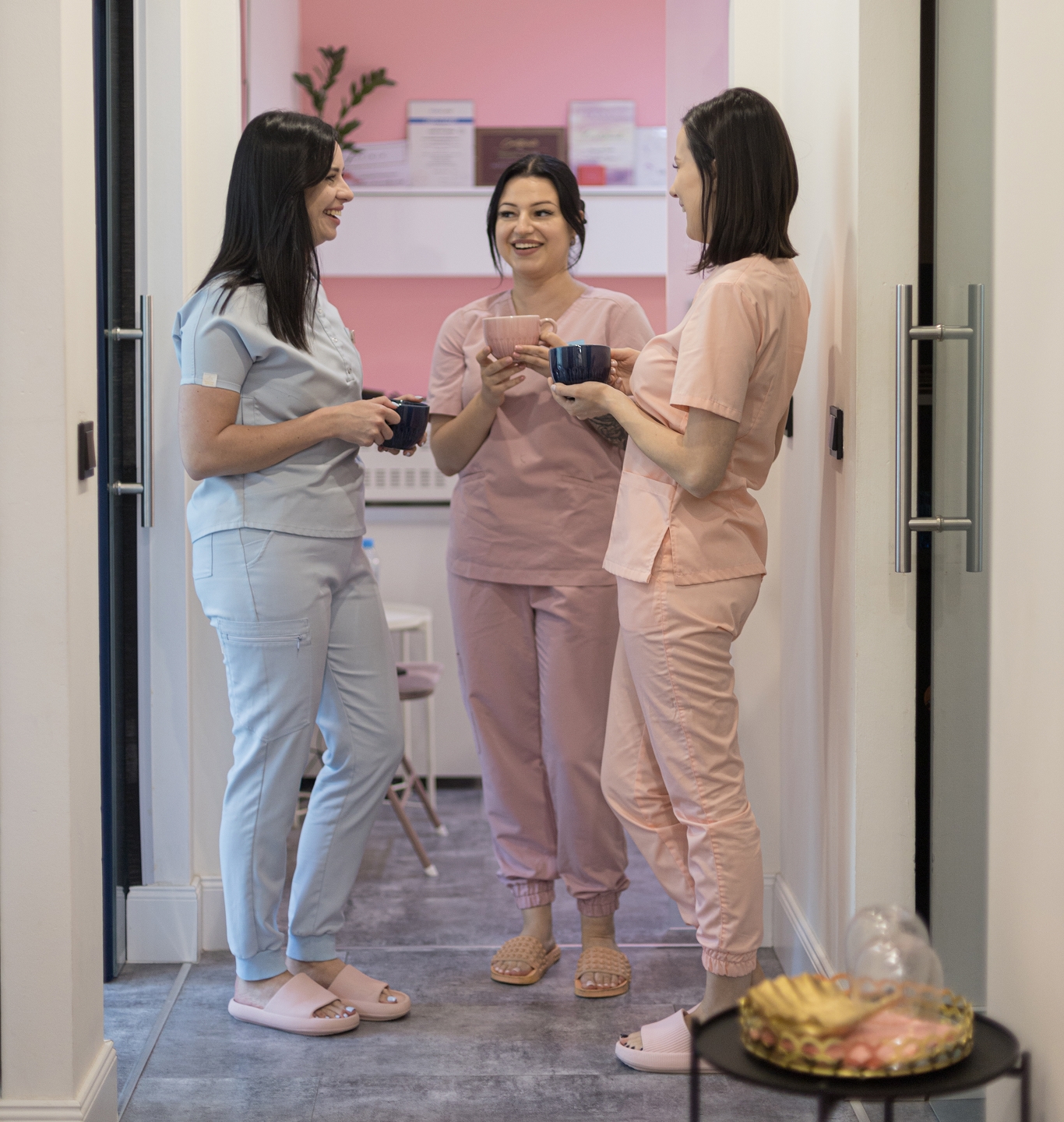 Zespół Gabinet Dziewczyny - trzy specjalistki w pastelowych uniformach, pozujące w studio na białym tle, promieniujące profesjonalizmem i serdecznością.